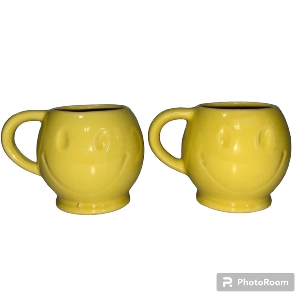 Smiley Face mugs. Sold as a pair. Bright yellow with eyes and smile‎ impression.